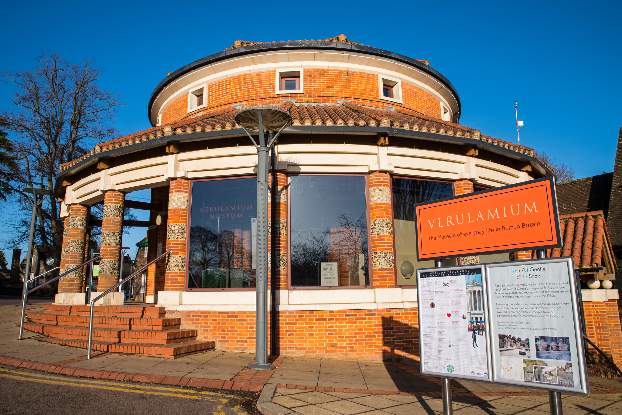 Verulamium Museum in St Albans on a bright day, its circular brick frontage and bold orange sign marking one of the city&rsquo;s key Roman-history attractions.